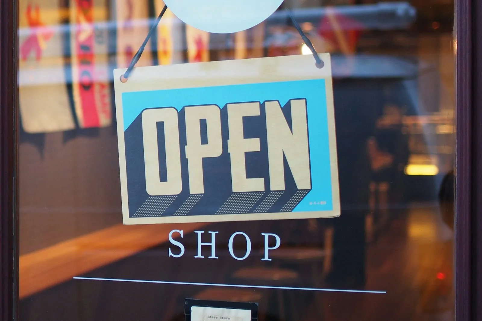 Open sign hanging in a shop window
